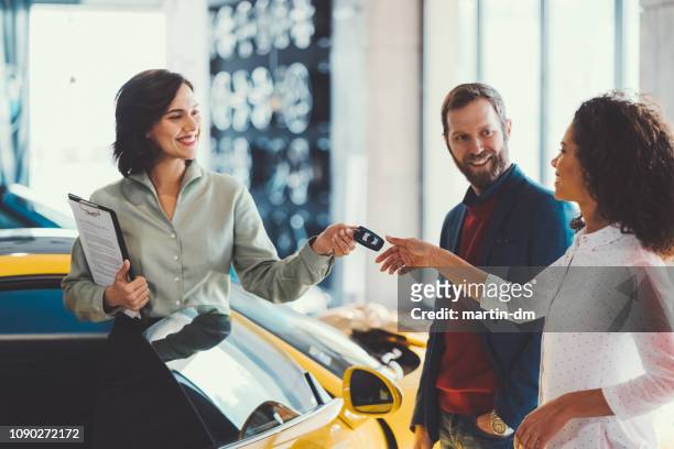 vrouw genieten van een nieuwe auto - car salesman stockfoto's en -beelden