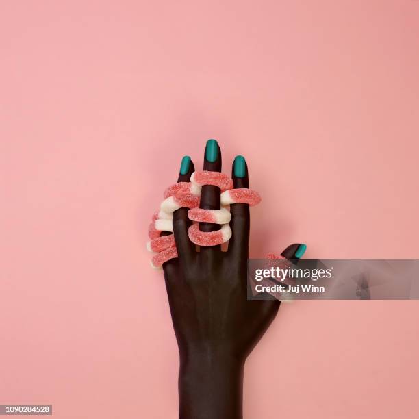 dark skinned hand wearing gel candy rings - fingernail foto e immagini stock