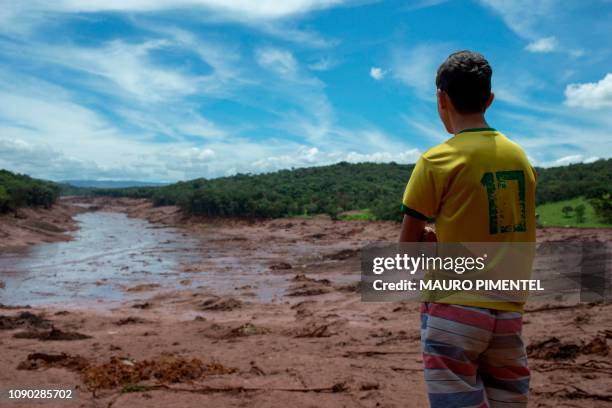 Boy looks at an area in the community of Casa Grande affected by a sludge after the collapse, two days ago, of a dam at an iron-ore mine belonging to...