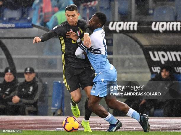 Lazio's Angolan defender Bastos holds off Juventus' Portuguese forward Cristiano Ronaldo during the italian Serie A football match Lazio Roma vs...