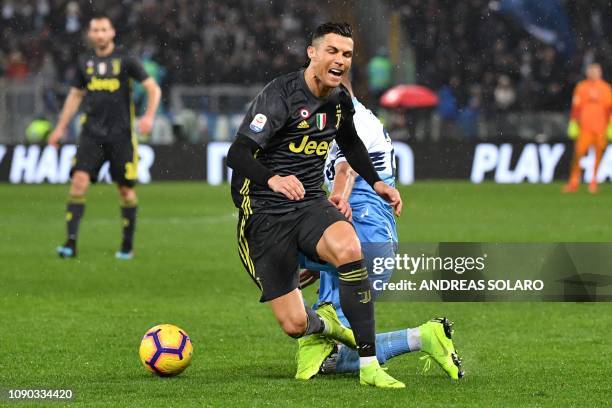 Juventus' Portuguese forward Cristiano Ronaldo is tackled during the italian Serie A football match Lazio Roma vs Juventus on January 27, 2019 at the...