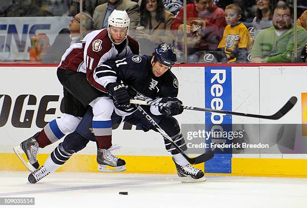 Philippe Dupuis of the Colorado Avalanche jumps on the back of David Legwand of the Nashville Predators on February 12, 2011 at the Bridgestone Arena...