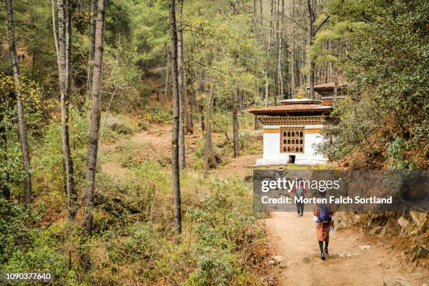 people walk towards tiger's nest monastery in paro, bhutan springtime - taktsang monastery stock pictures, royalty-free photos & images