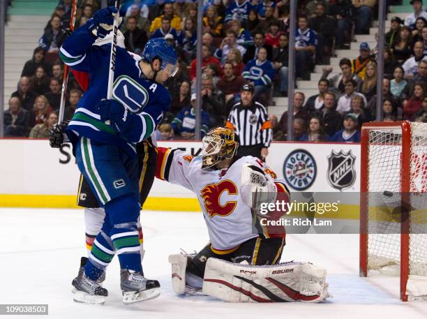 Ryan Kesler of the Vancouver Canucks watches teammate Mikael Samuelsson's shot hit the back of the net past goalie Miikka Kiprusoff of the Calgary...