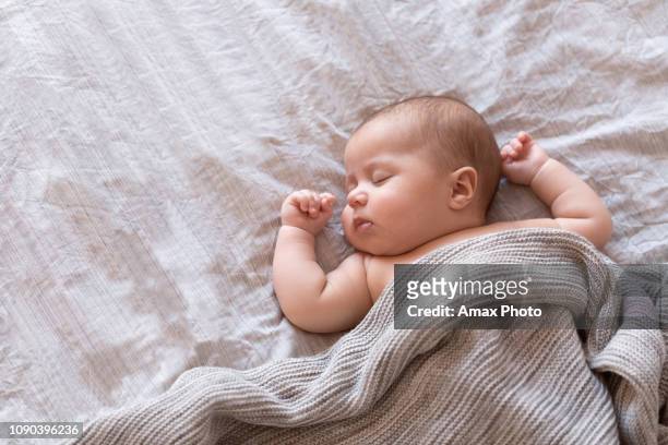 bebé tranquilo acostado en una cama y dormir en casa - baby girls fotografías e imágenes de stock