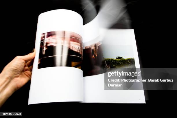 looking through magazine, turning pages - magazijn stock-fotos und bilder