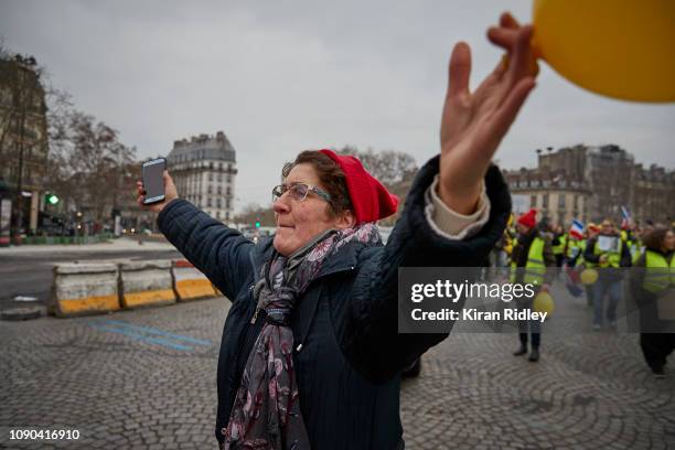 Female Gilets Jaune or Yellow Vest protestor taunts the French Police during demonstrations at Place de la Bastille as part of the Women only 'Gilets...