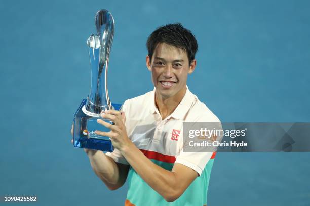 Kei Nishikori of Japan plays hold the winners trophy after thd Men’s Finals match against Daniil Medvedev of Russia during day eight of the 2019...