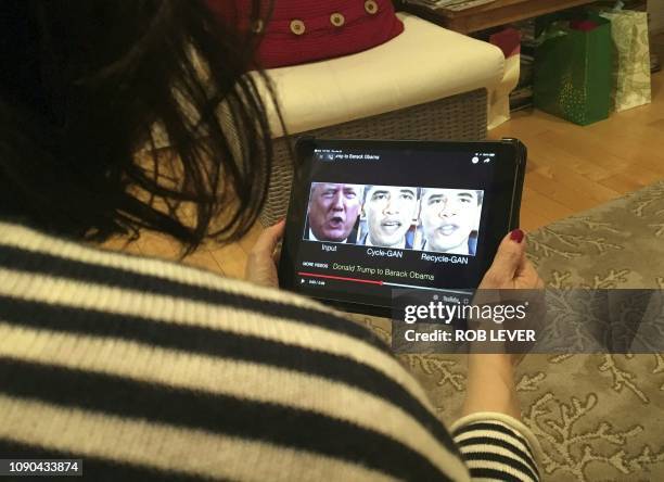 Woman in Washington, DC, views a manipulated video on January 24 that changes what is said by President Donald Trump and former president Barack...