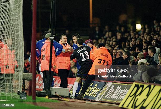 John Terry of Chelsea is helped back onto the pitch by stewards and team-mate Carlo Cudicini after he fell into the crowd during the AXA sponsored FA...