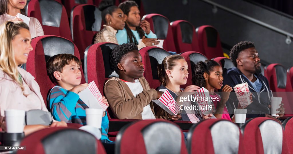 Familjer och vänner i biograf, äta popcorn