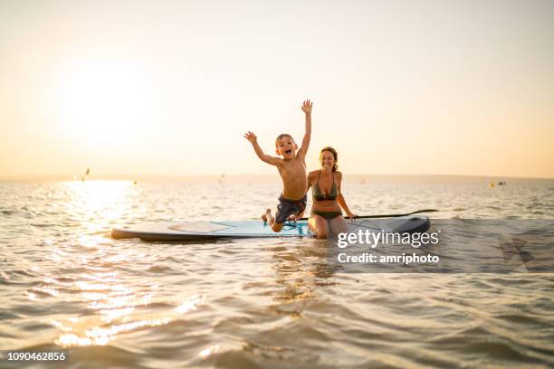 niño feliz saltando en el lago - agua estancada fotografías e imágenes de stock