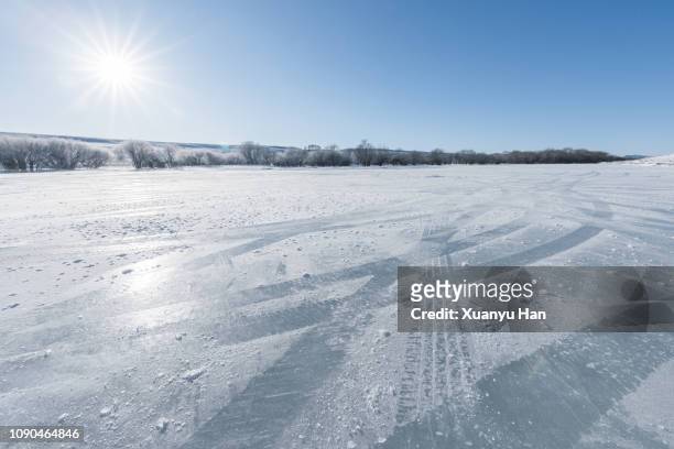 vehicle tracks through thick layer of ice, with blue sky - water surface stock pictures, royalty-free photos & images