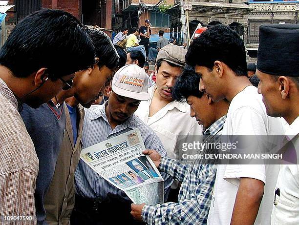 People crowd round to read a newspaper reporting the massacre of the Nepalese Royal family in Kathmandu, 02 June 2001. King Birendra of Nepal and...