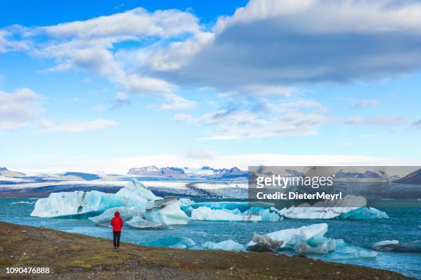 viajero en hielo surrealista paisaje en jokulsarlon, islandia - jokulsarlon lagoon fotografías e imágenes de stock