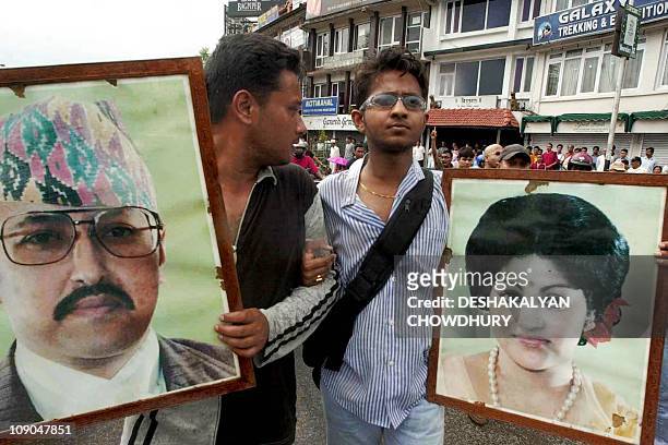 Two young supporters of the royal family carry portraits of King Birendra and Queen Aishwarya during a rally in Kathmandu 03 June 2001 to mourn the...