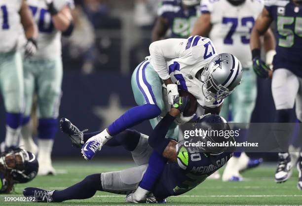 Allen Hurns of the Dallas Cowboys suffers a leg injury while tackled by Bradley McDougald of the Seattle Seahawks in the first quarter of the Wild...