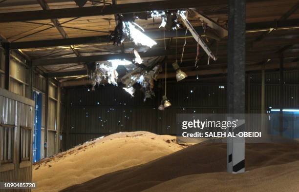 Piles of grains lie at a damaged warehouse of Yemen's Red sea mills company in the port city of Hodeida on January 22, 2019. - Gunshots reverberate...