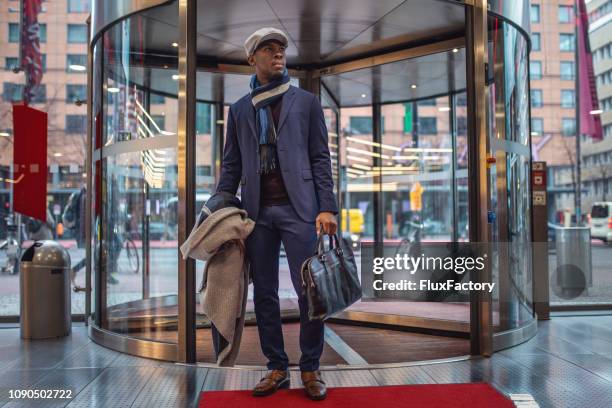 handsome businessman entering the mall through a revolving door - entering a men in a mall stock pictures, royalty-free photos & images