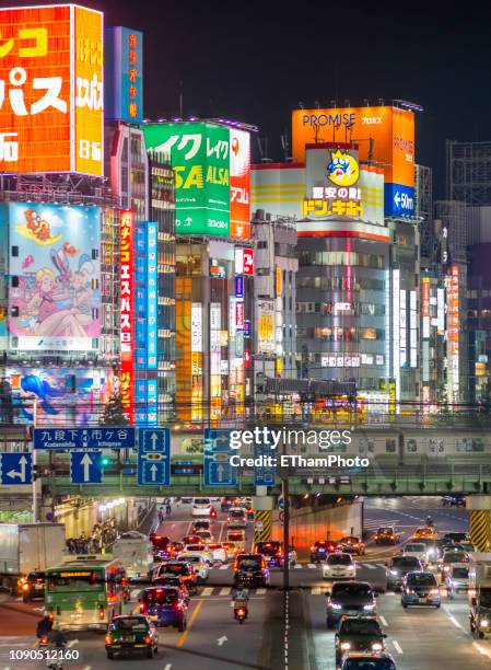 traffic outside shinjuku station at night (tokyo, japan) - shinjuku stock pictures, royalty-free photos & images