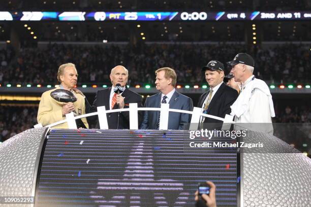 Hall of Fame quarterback Roger Staubach presents the Vince Lombardi Trophy to NFL commissioner Roger Goodell as Hall of Famer Terry Bradshaw of Fox...