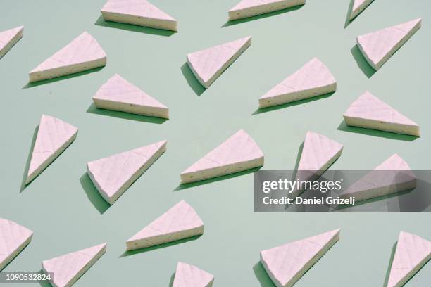 brie cheese placed in a repetative pattern - brie stock pictures, royalty-free photos & images