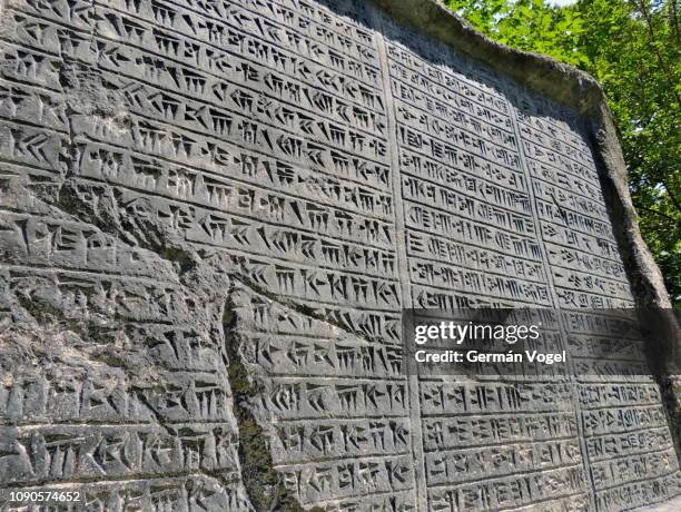 large cuneiform stone carved document from mesopotamia and early persia at park in niavaran, tehran, iran - imitation - cuneiforme imagens e fotografias de stock