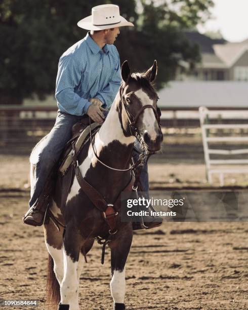 cowboy horseback riding on the farm. - handsome cowboy stock pictures, royalty-free photos & images