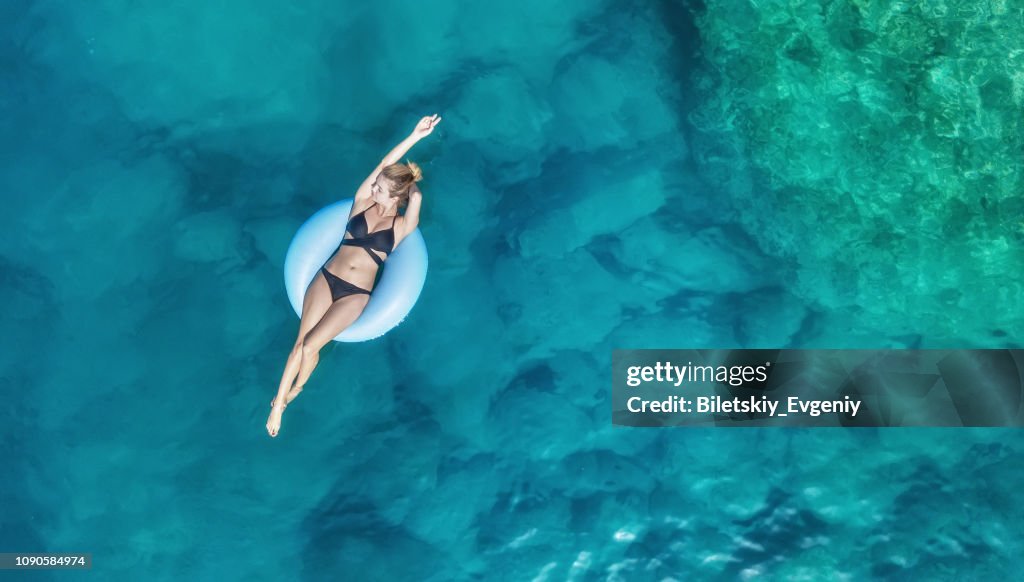 Luchtfoto op het meisje op zee. Turquoise water uit de lucht als een achtergrond uit de lucht. Natuurlijke zeegezicht op de zomertijd. Zeegezicht van drone