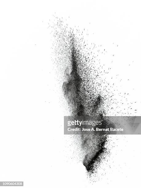 explosion by an impact of a cloud of particles of powder of color black on a white background. - sand dust stock pictures, royalty-free photos & images