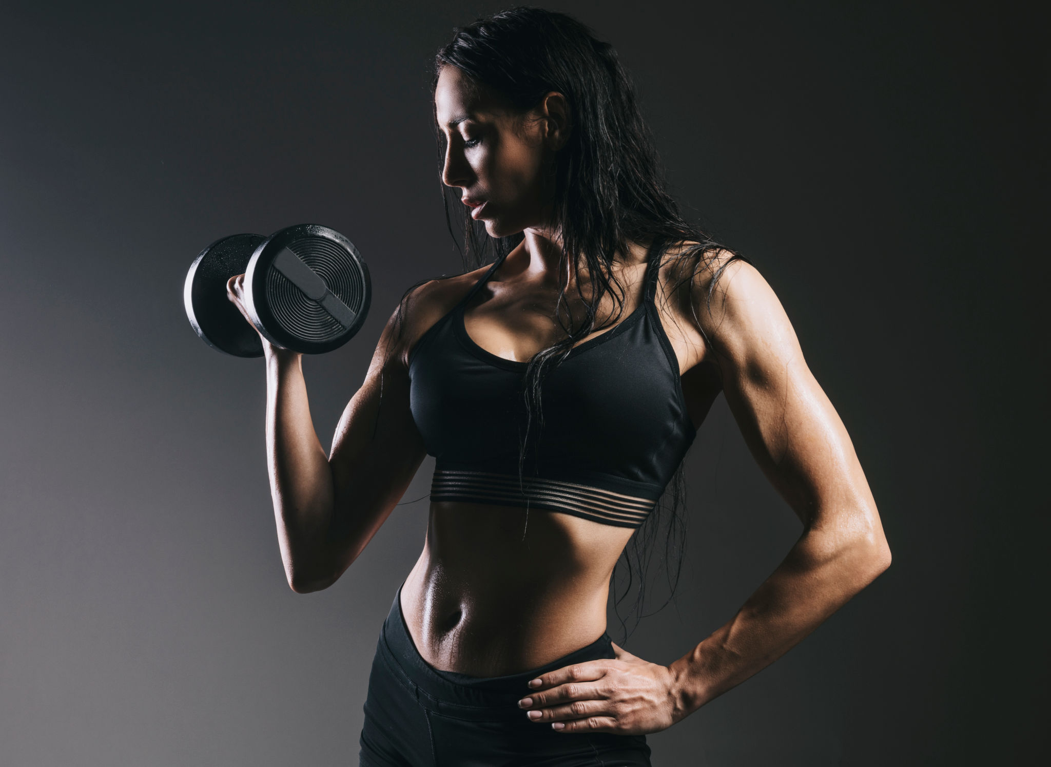 fit woman with barbell front of the grey background fit woman with barbell front of the grey background