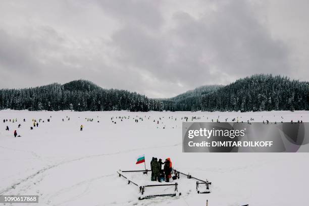 Anglers take part in the XVI World Ice Fishing Championship in Shiroka Polyana dam near Batak on January 26, 2019. - They battled with snow drifts...