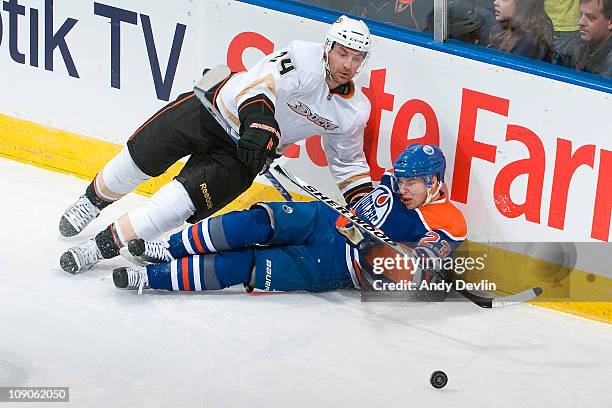 Linus Omark of the Edmonton Oilers takes a hit from Francois Beauchemin of the Anaheim Ducks at Rexall Place on February 13, 2011 in Edmonton,...