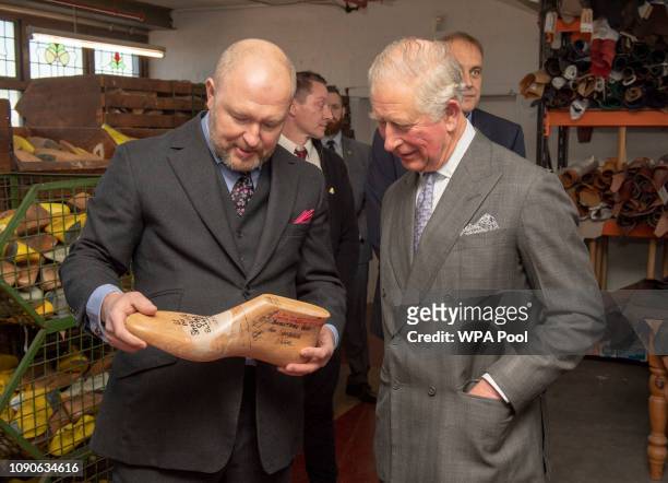Prince Charles, Prince of Wales speaks with Michael James who shows the Prince the size 22 shoe last for US Basketball star Shaquille O'Neal as he...