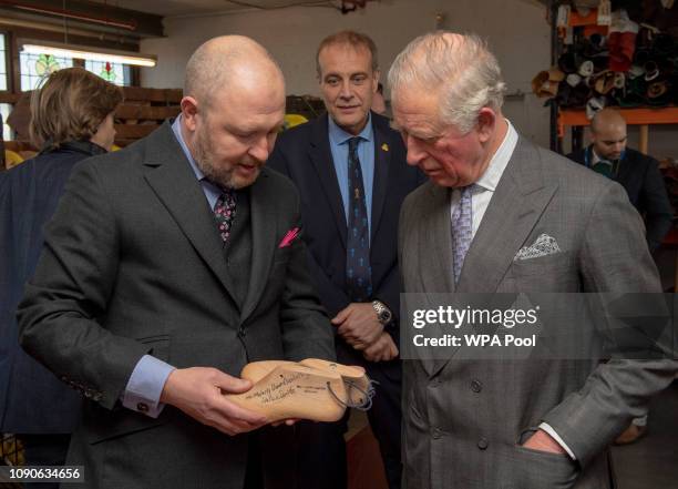 Prince Charles, Prince of Wales speaks with Michael James who shows the Prince the size 22 shoe last for US Basketball star Shaquille O'Neal as he...