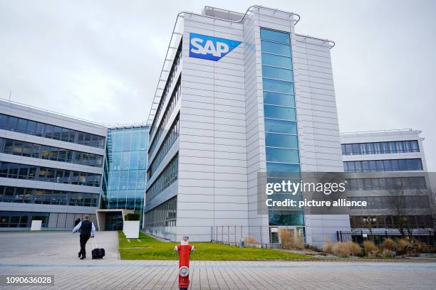 January 2019, Baden-Wuerttemberg, Walldorf: A man passes a building of the headquarters of the software company SAP. The company will announce its...