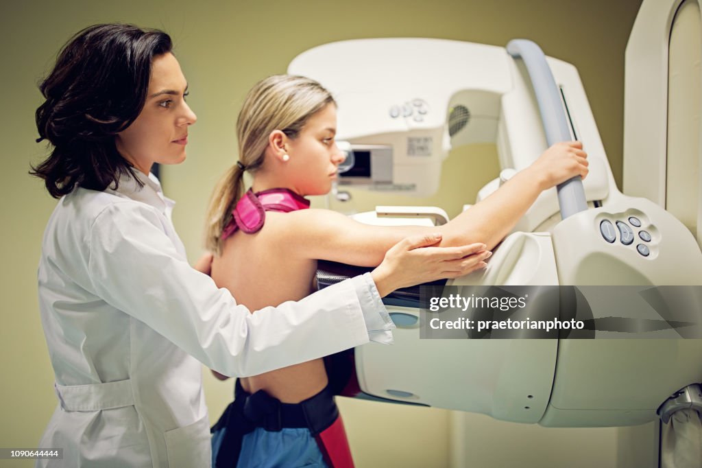 Médico está trabajando con el escáner de rayos x de la mamografía en el hospital