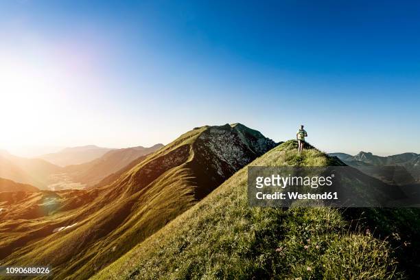 germany, allgaeu alps, woman running on mountain ridge - distante stock pictures, royalty-free photos & images