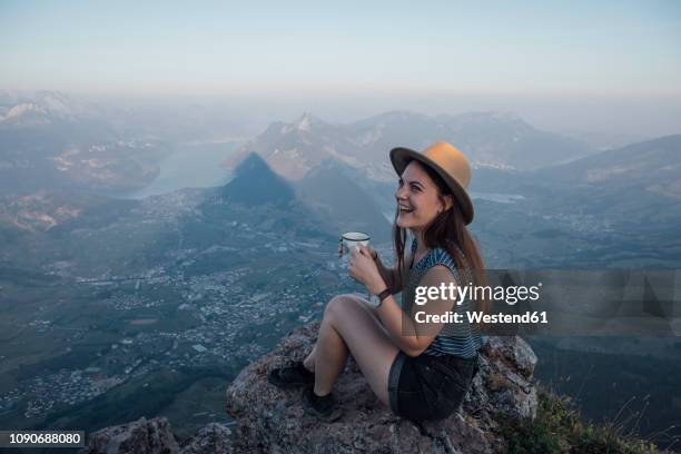 switzerland, grosser mythen, happy young woman on a hiking trip sitting on a rock with a cup - coffee top view stock-fotos und bilder