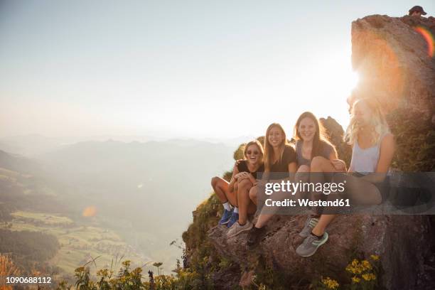 switzerland, grosser mythen, four happy girlfriends on a hiking trip having a break at sunrise - fun sommer berge stock-fotos und bilder