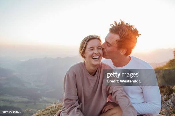 switzerland, grosser mythen, happy young couple on a hiking trip having a break at sunrise - happy couple stockfoto's en -beelden