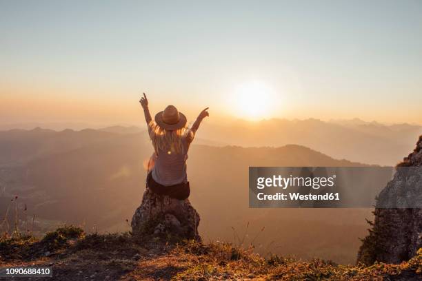 switzerland, grosser mythen, young woman on a hiking trip sitting on a rock at sunrise - majestätisch stock-fotos und bilder