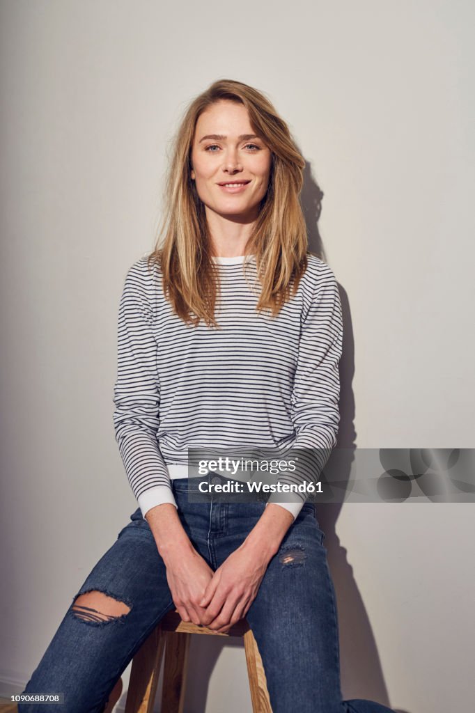 Portrait of smiling woman sitting on stool