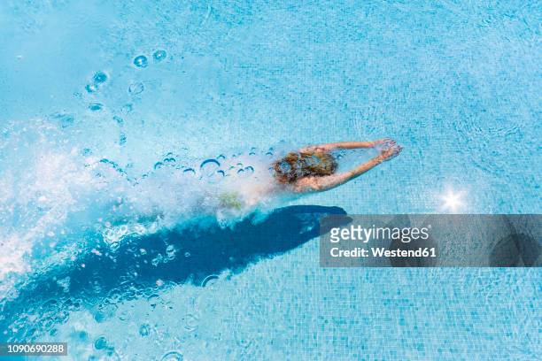 spain, woman diving in swimming pool - women by pool stock-fotos und bilder