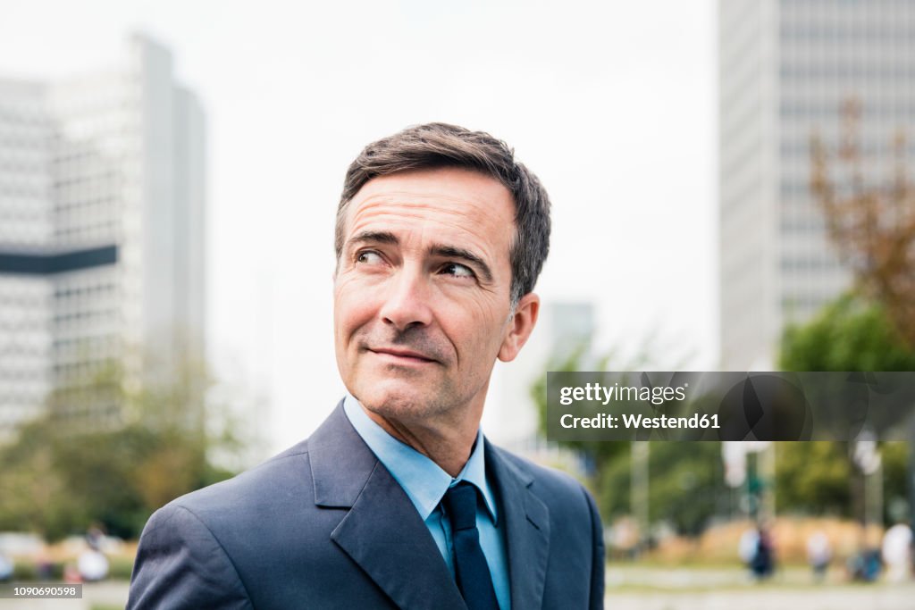 Portrait of confident businessman in the city looking sideways