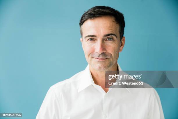 portrait of confident mature businessman - farbiger hintergrund stock-fotos und bilder