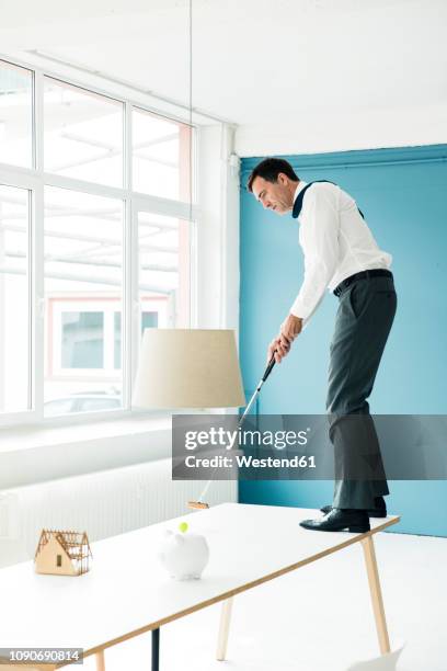 businessman playing golf on table in office - golf club house stock pictures, royalty-free photos & images