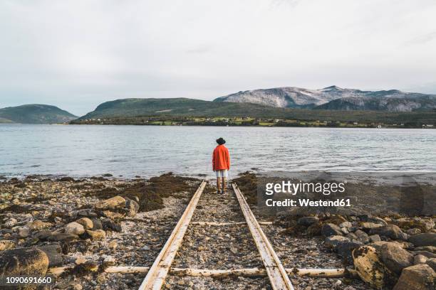 northern norway, man standing alone at fjord, looking at view - dead end stock pictures, royalty-free photos & images
