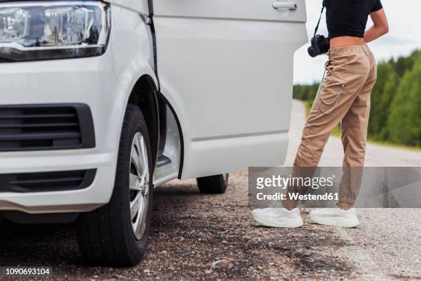 finland, lapland, young woman at country road getting into a car - car isolated doors open stock pictures, royalty-free photos & images