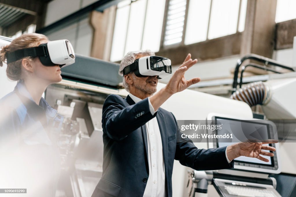Businessman and skilled worker in high tech enterprise, using VR glasses